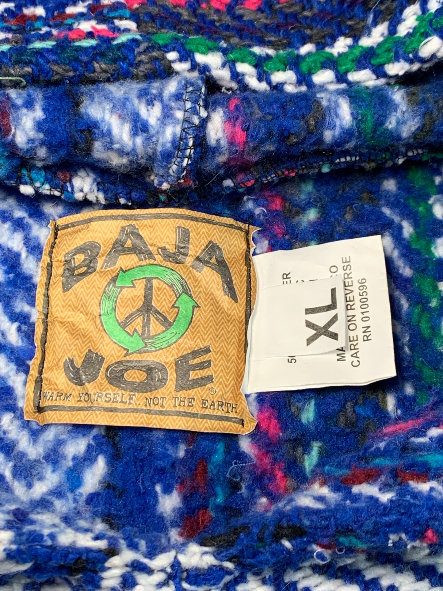 Close-up of a colorful fabric with a label and patch on a multicolored background