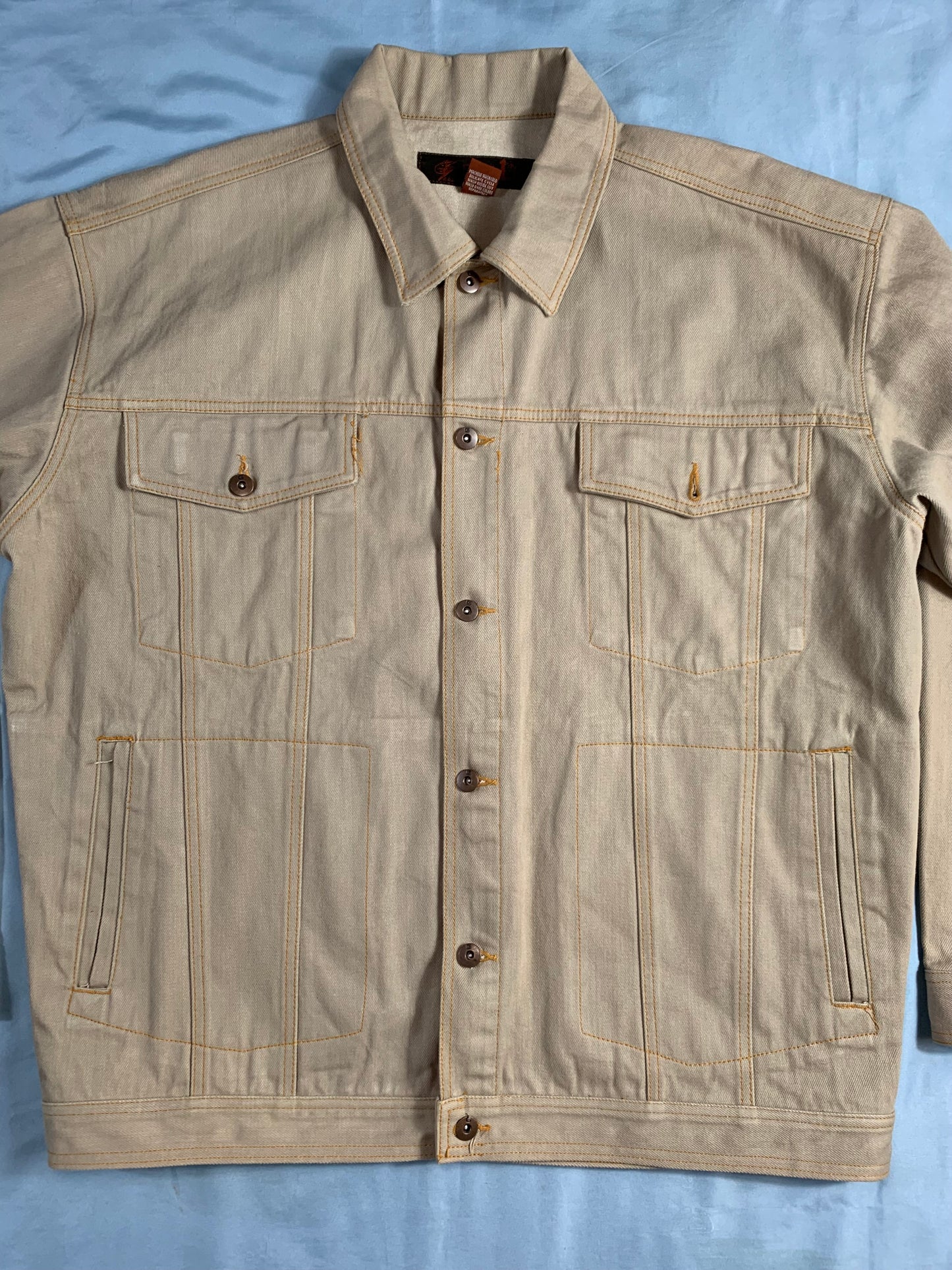 Beige jacket with button details on a light blue background