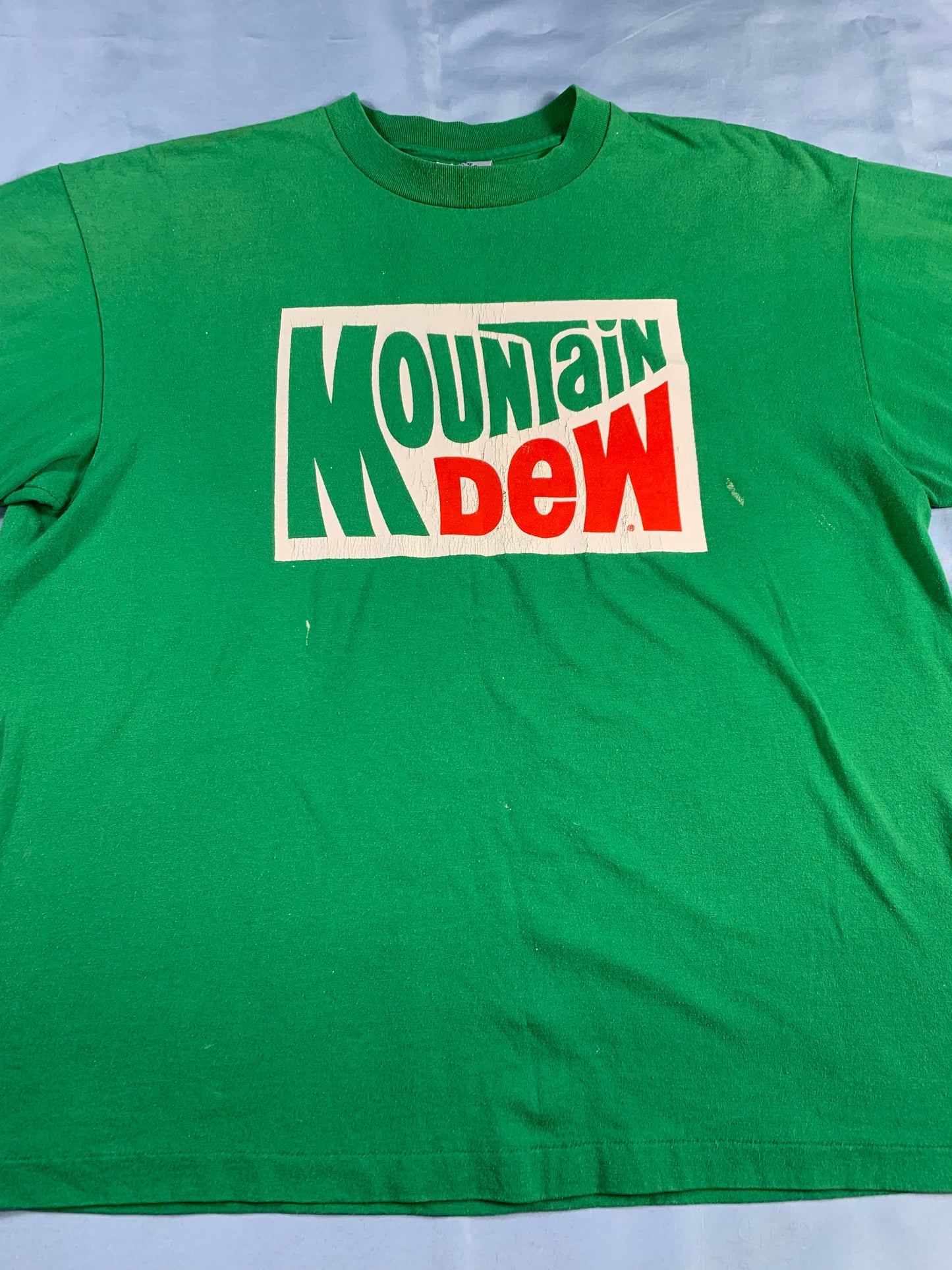 Green t-shirt with Mountain Dew logo on a white background