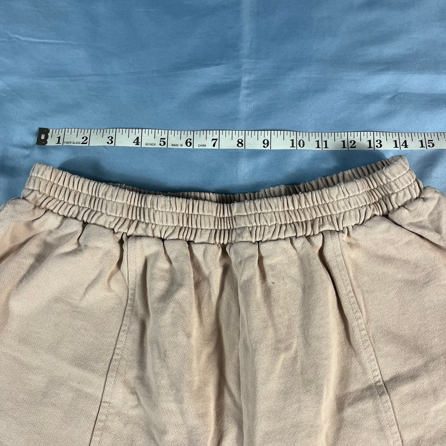 Beige pants with a measuring tape on a blue background