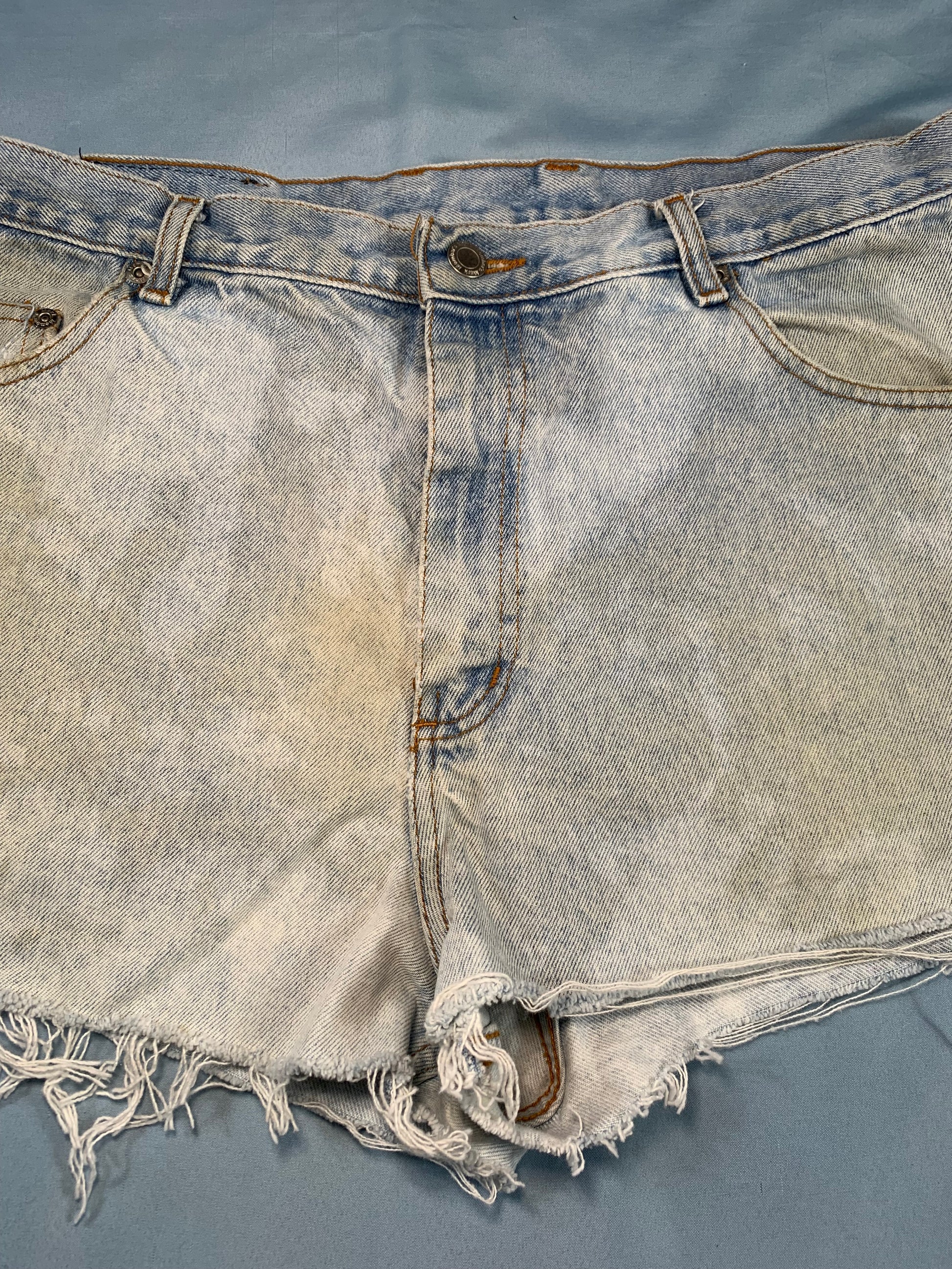Denim vest with frayed edges on a gray background