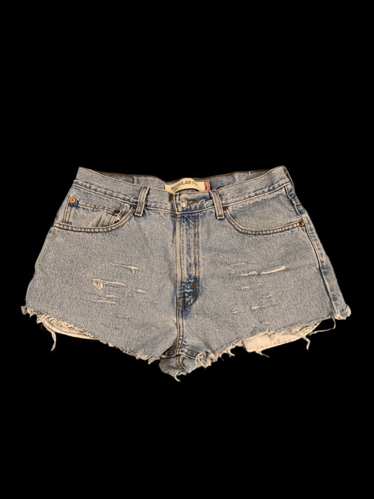 Distressed denim shorts on a gray background