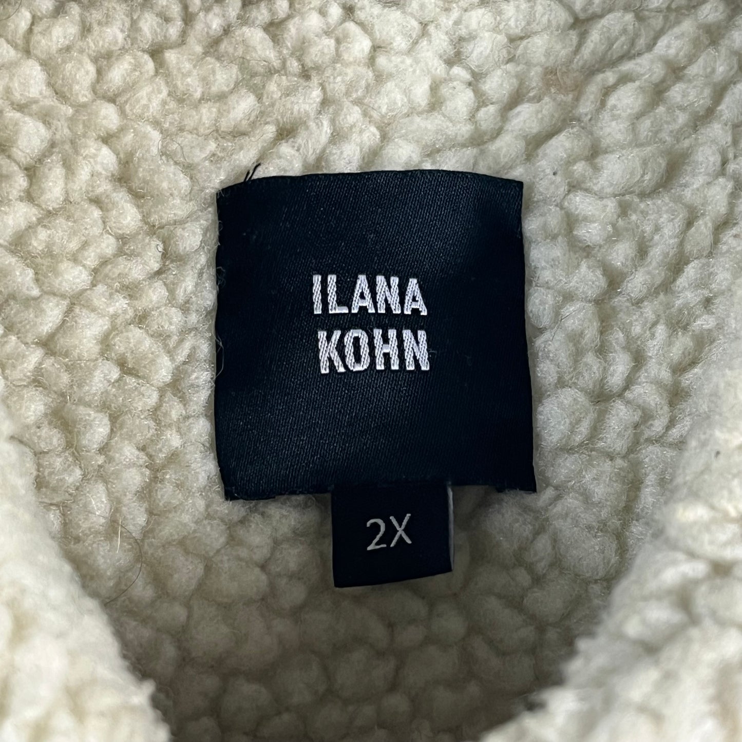 Black label with 'ILANA KOHN' and size '2X' on a textured fabric background