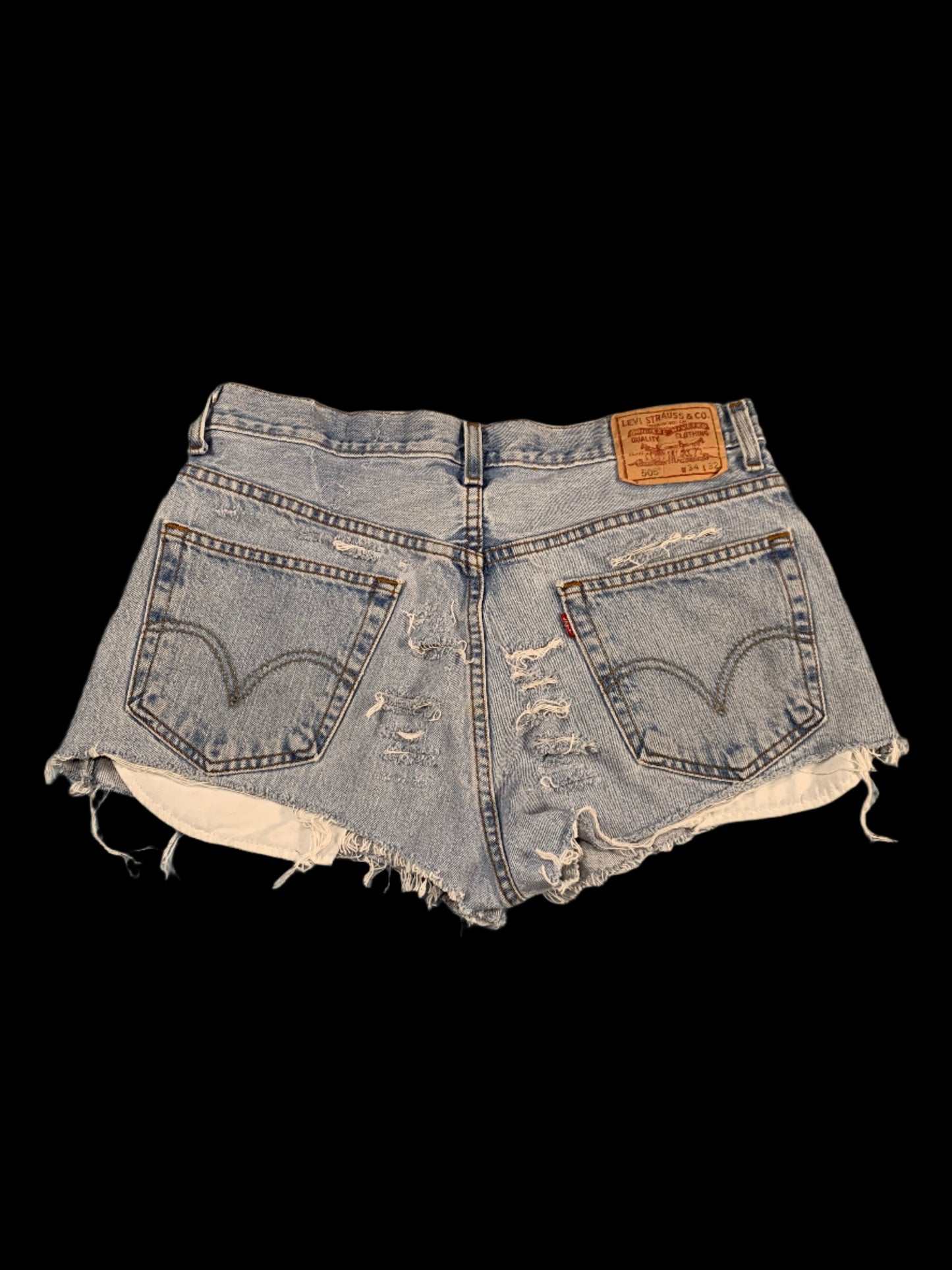 Pair of distressed denim shorts on a gray surface
