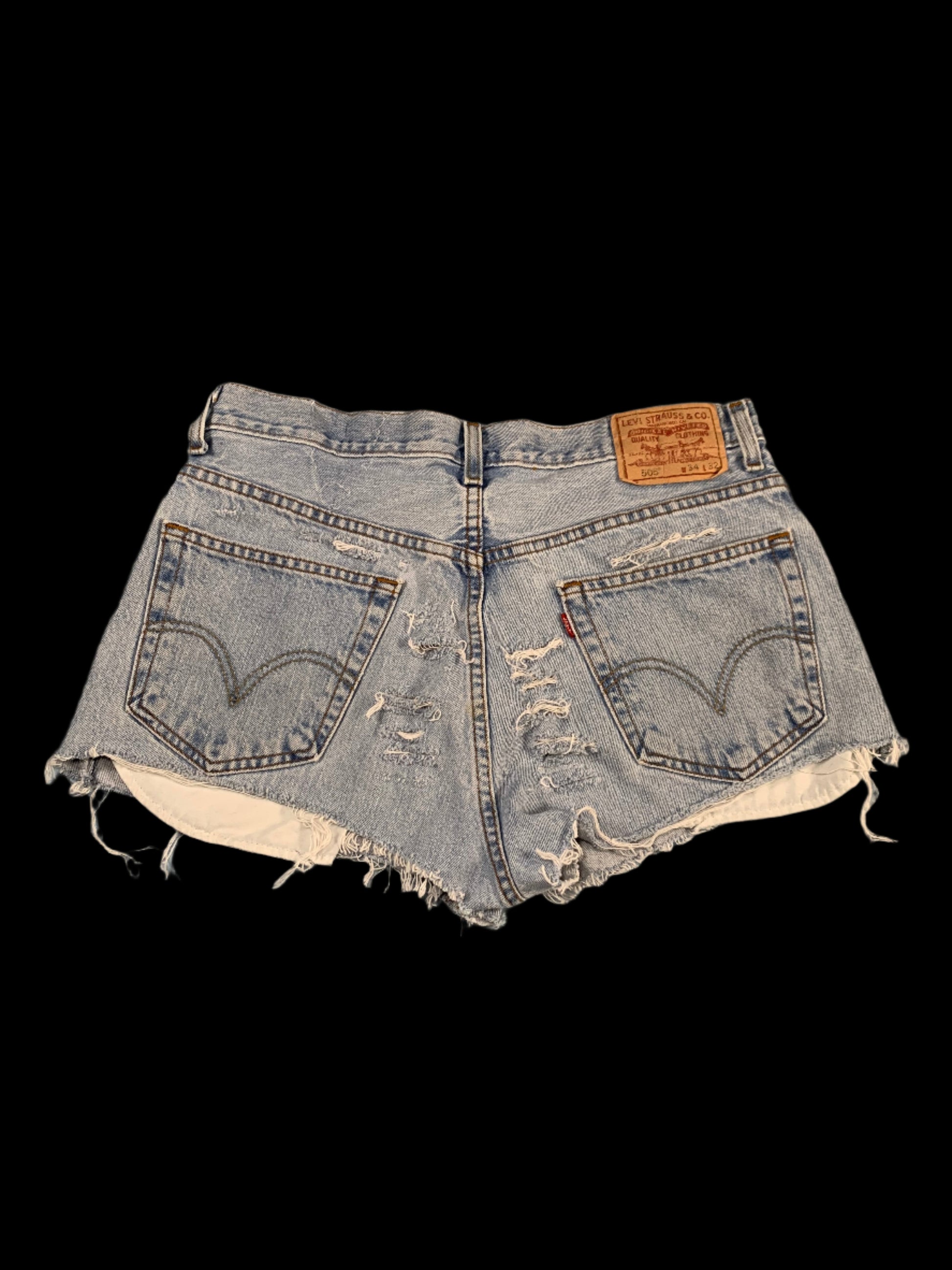 Pair of distressed denim shorts on a gray surface