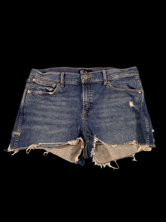 Distressed denim shorts on a gray background