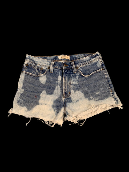 Distressed denim shorts on a gray surface