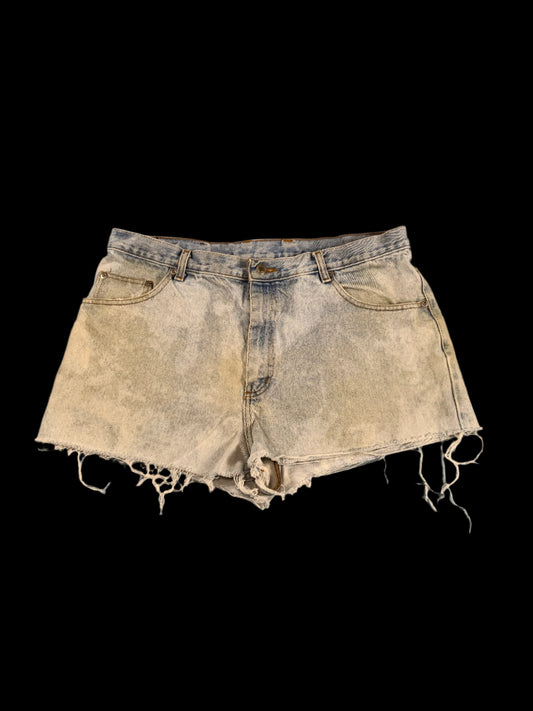 Distressed denim shorts on a gray surface