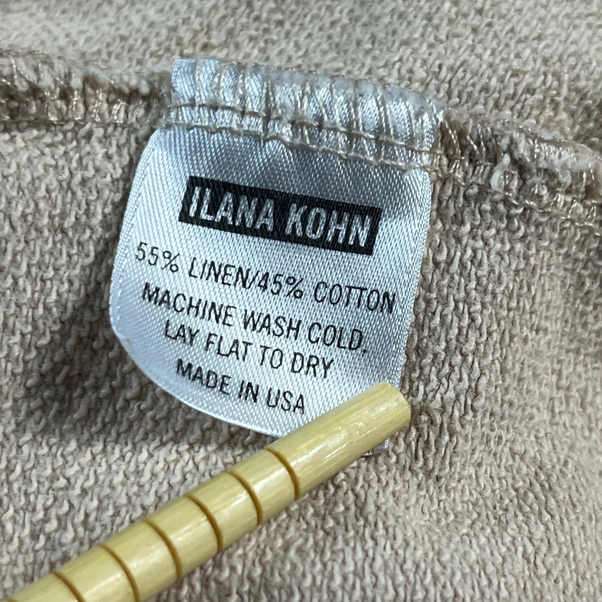 Fabric tag with 'Ilana Kohn' branding on a textured fabric background