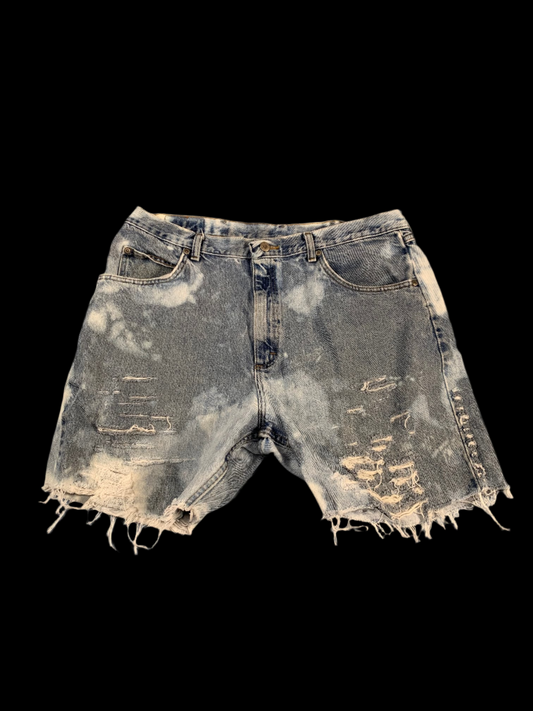 Distressed denim shorts on a gray background