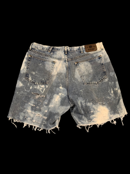 Distressed denim shorts on a gray background